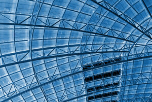 looking up at blue-tinted windows in a steel frame