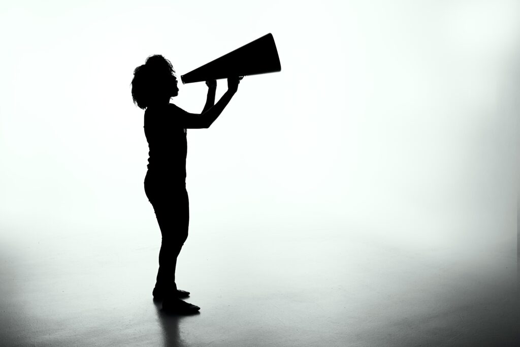 silhouette of woman holding analog megaphone